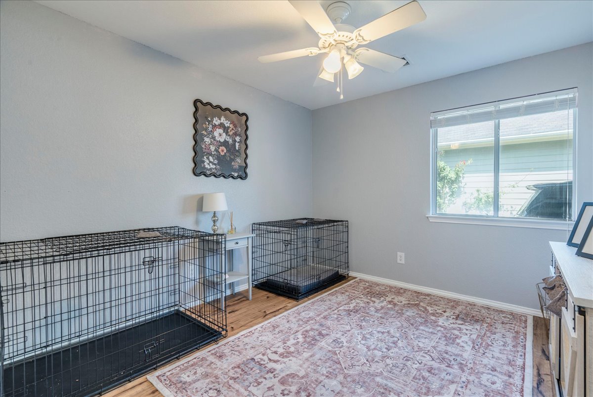 175 Wetzel Kyle, TX 78640 - Photo 20 of 27 A well-lit bedroom with wooden floors and a large window, offering a pleasant living space.