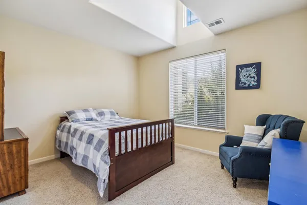 a bed sitting in a bedroom next to a window