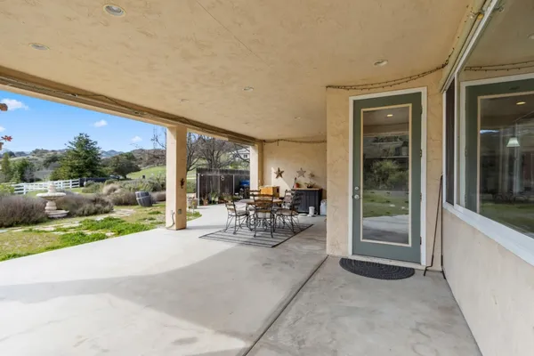 a view of a porch with chairs and floor to ceiling window