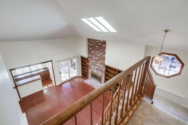 an empty room with chandelier fan and windows