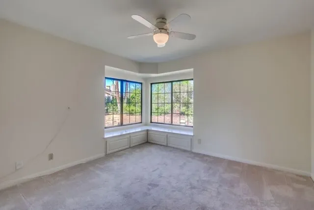 an empty room with closet and a chandelier fan