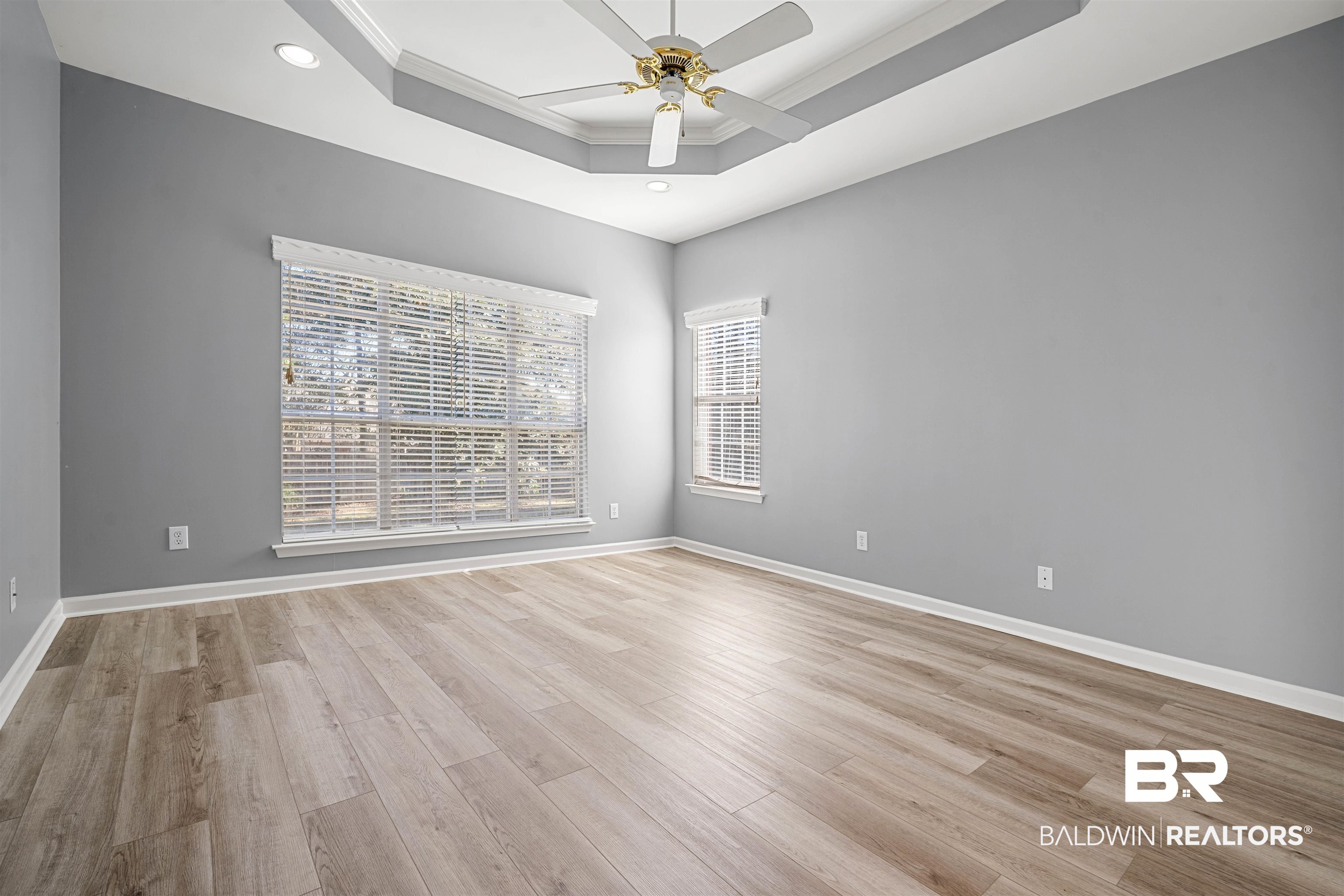 615 Summerlake Place Mobile, AL 36608 - Photo 15 of 35 Unfurnished room featuring light wood-type flooring, ornamental molding, a tray ceiling, and a ceiling fan