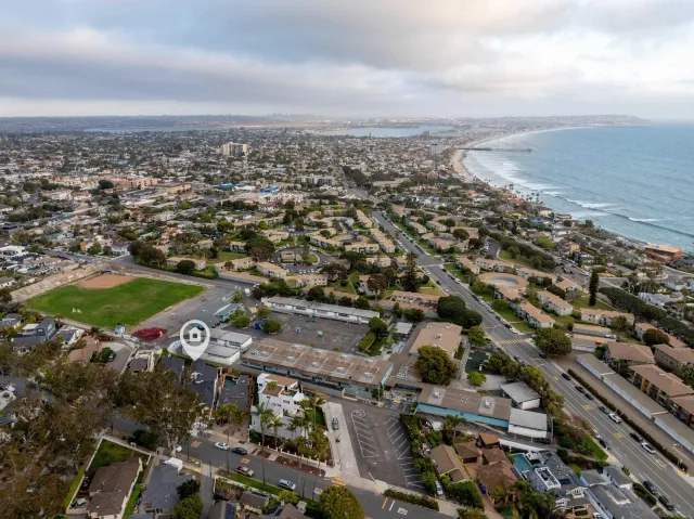 an aerial view of a city with ocean view in back