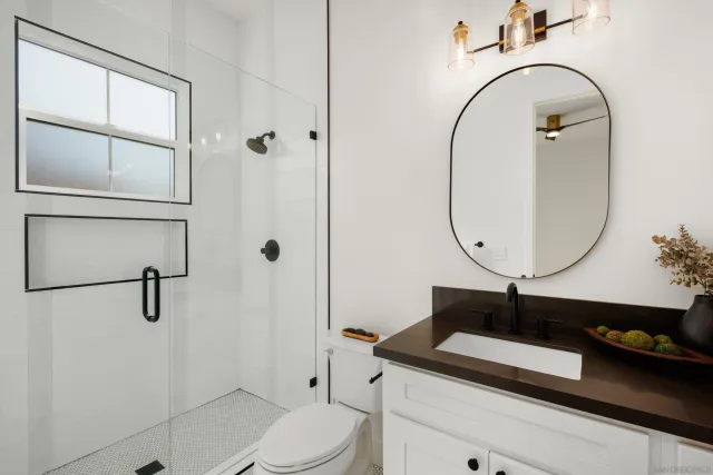 a bathroom with a sink a toilet and shower