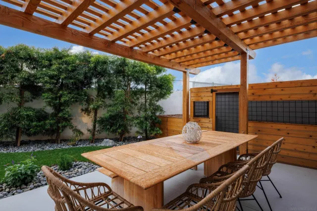 a view of a patio with table and chairs with wooden floor and fence