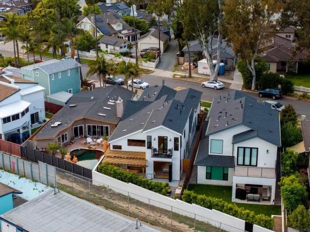 an aerial view of multiple houses with a street