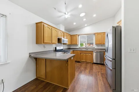 a kitchen with a sink appliances cabinets and wooden floor