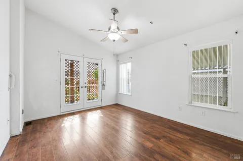 a view of an empty room with wooden floor and a window