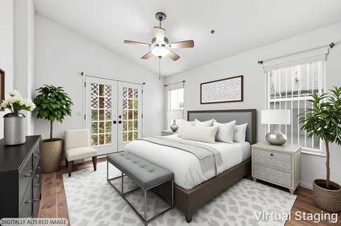 a bedroom with a large bed and a potted plant