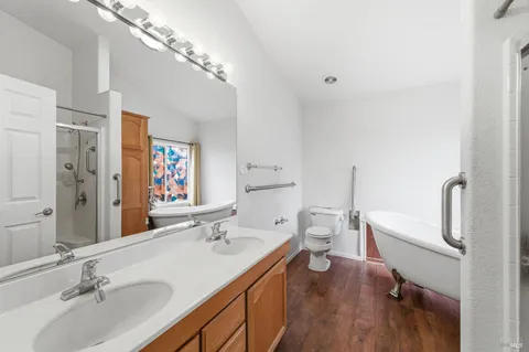 a bathroom with a granite countertop sink a toilet a large mirror and shower