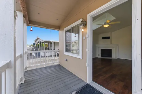 a view of a hallway with wooden floor and a living room