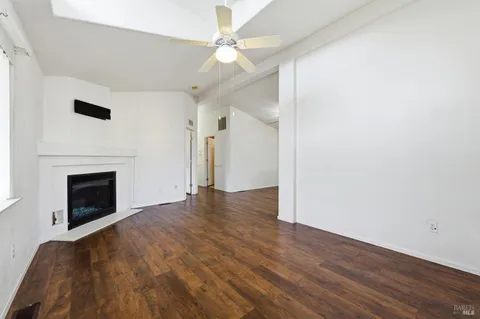 a view of empty room with wooden floor and fireplace