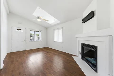 an empty room with windows and fireplace