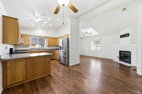 a large kitchen with cabinets wooden floor and stainless steel appliances