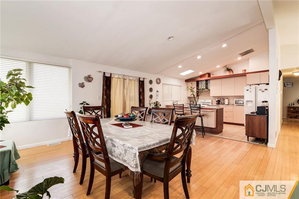 17 Wilk Road Edison, NJ 08837 - Photo 7 of 22 a view of a dining room and livingroom with furniture wooden floor a rug a painting and a chandelier