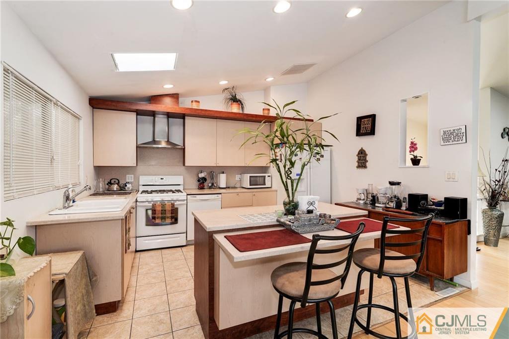 17 Wilk Road Edison, NJ 08837 - Photo 9 of 22 a kitchen with a table chairs stove and microwave