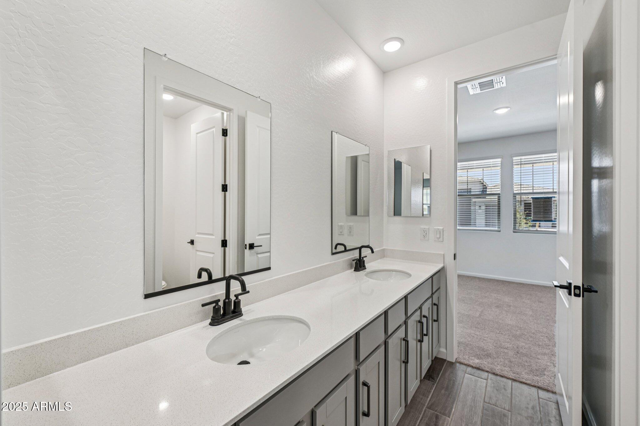 15794 West Cheryl Drive Waddell, AZ 85355 - Photo 16 of 53 a bathroom with a sink double vanity granite tub shower and a mirror