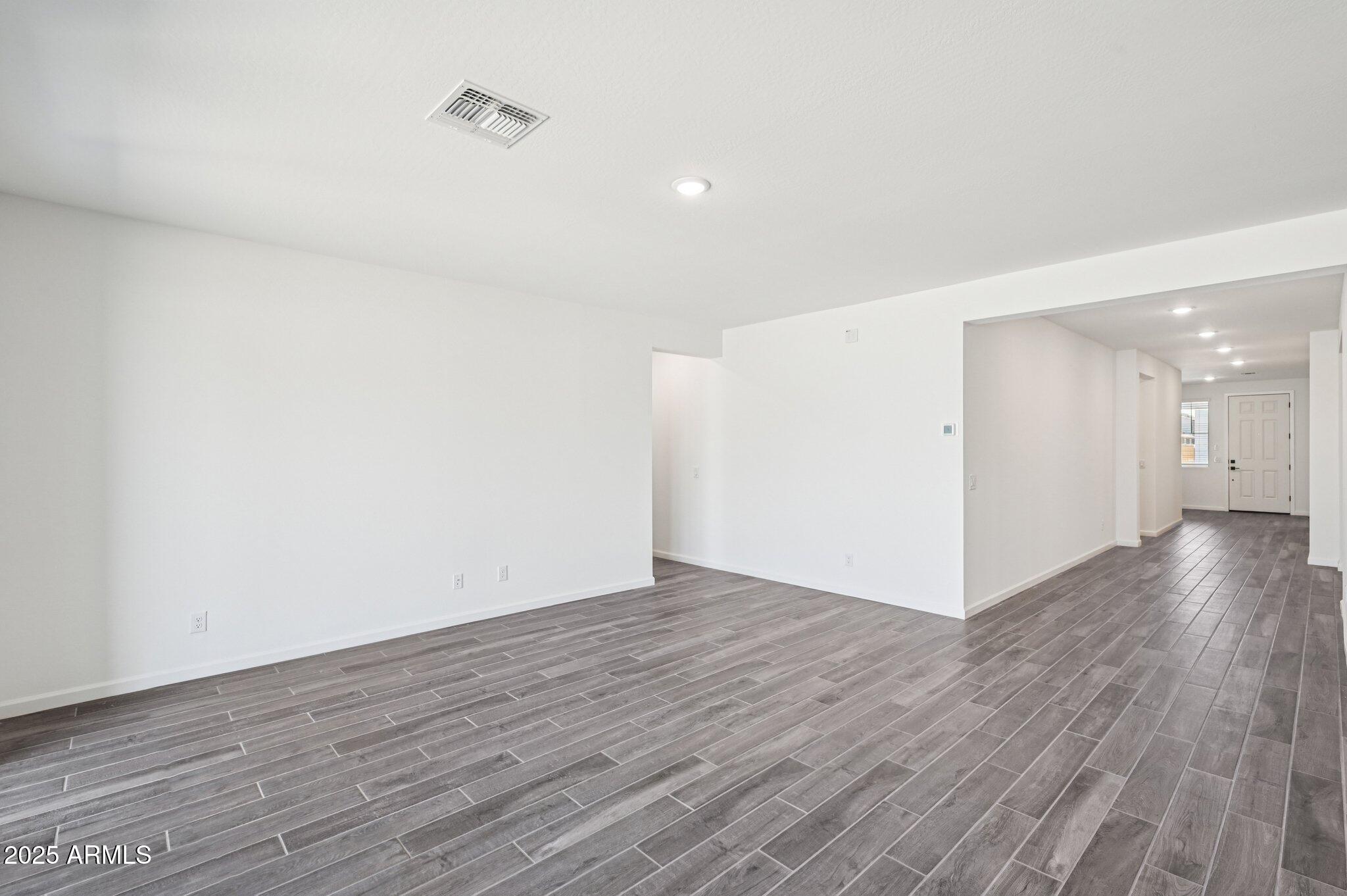 15794 West Cheryl Drive Waddell, AZ 85355 - Photo 31 of 53 a view of an empty room with wooden floor and a window
