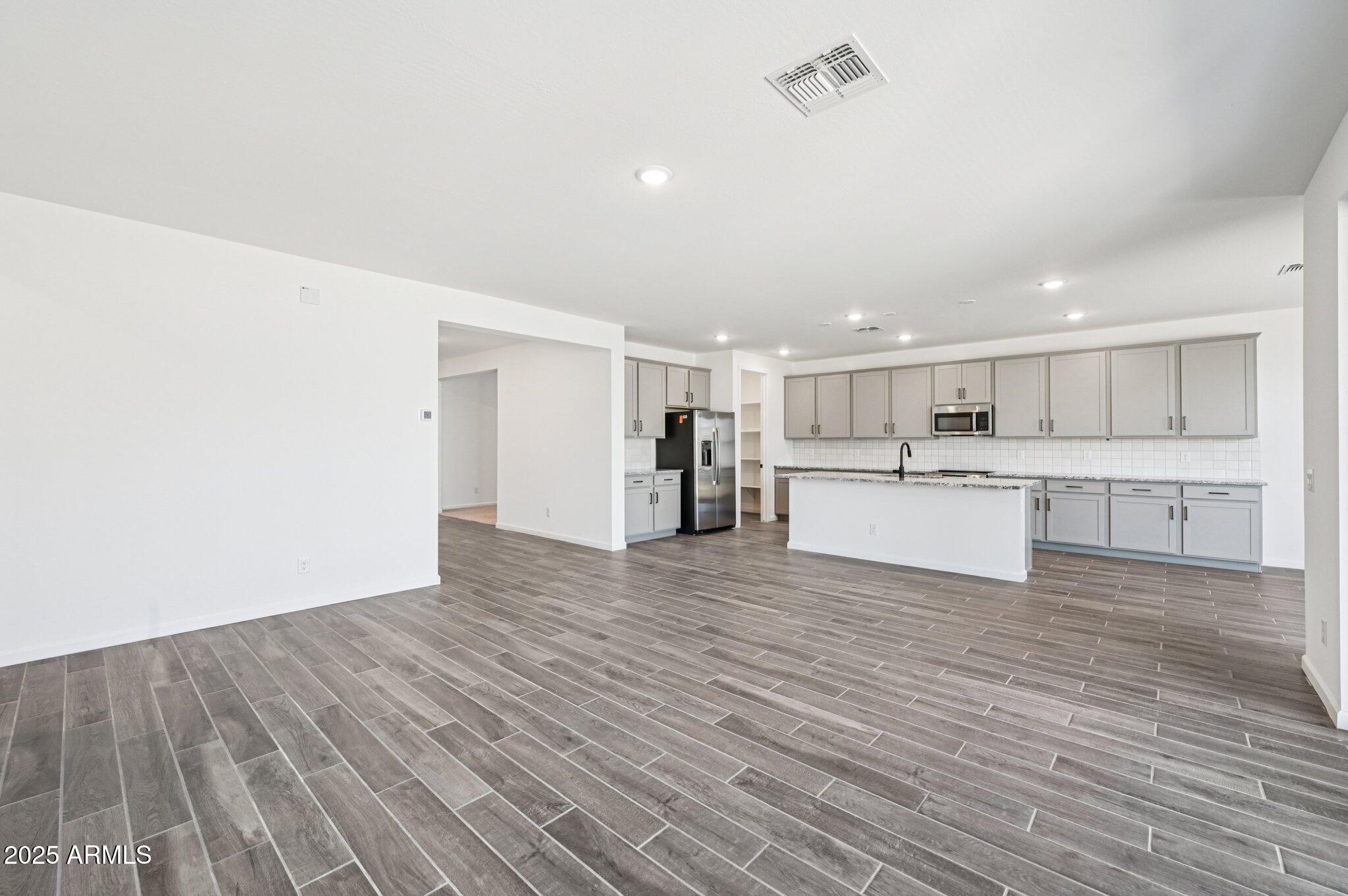 15794 West Cheryl Drive Waddell, AZ 85355 - Photo 5 of 53 a view of a kitchen with wooden floor and a window