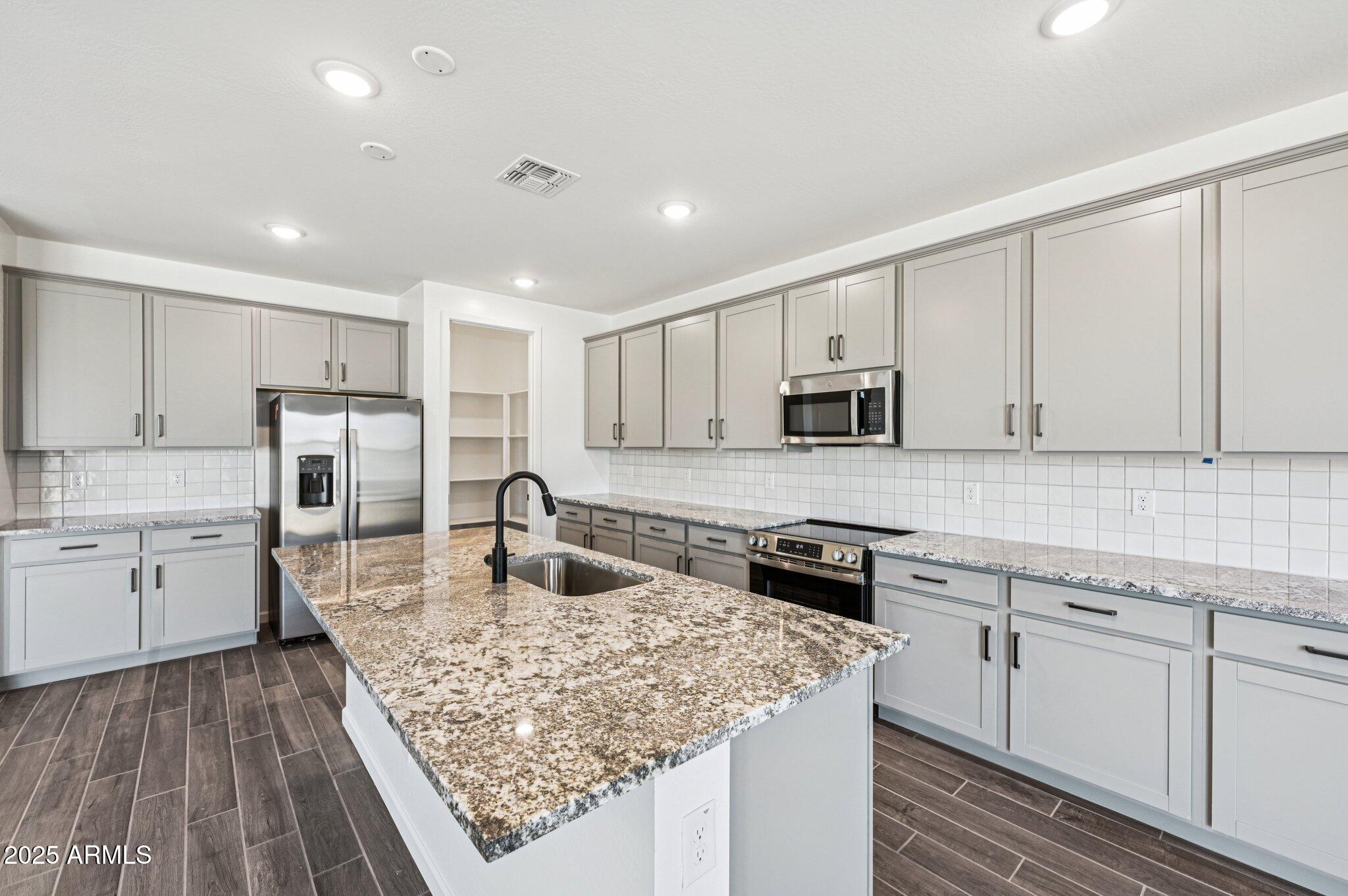 15794 West Cheryl Drive Waddell, AZ 85355 - Photo 9 of 53 a kitchen with sink stove microwave and refrigerator
