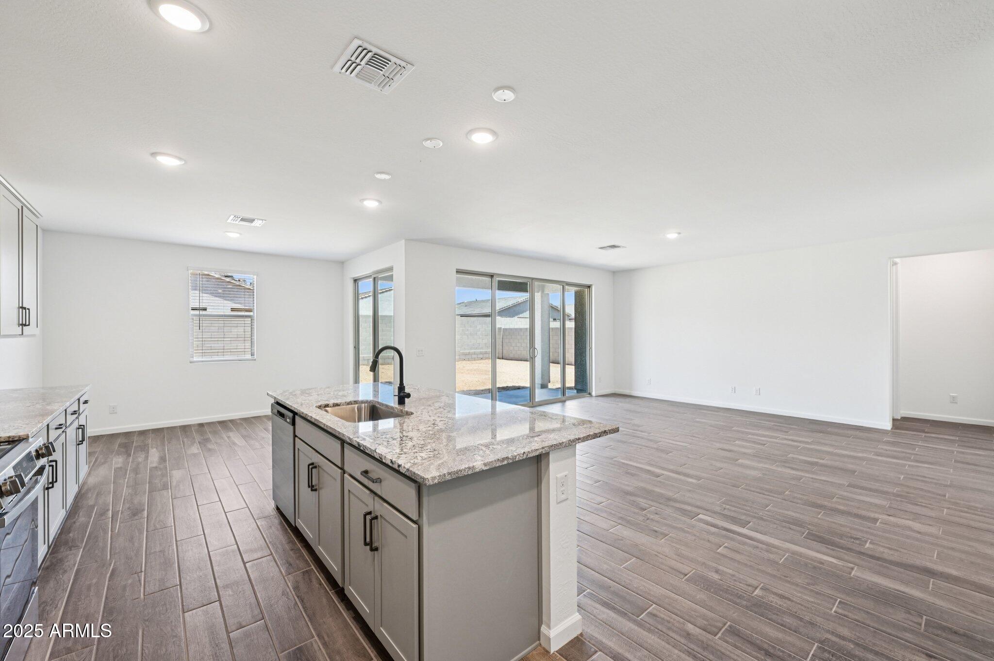 15794 West Cheryl Drive Waddell, AZ 85355 - Photo 10 of 53 a kitchen island with granite countertop a sink and wooden floor