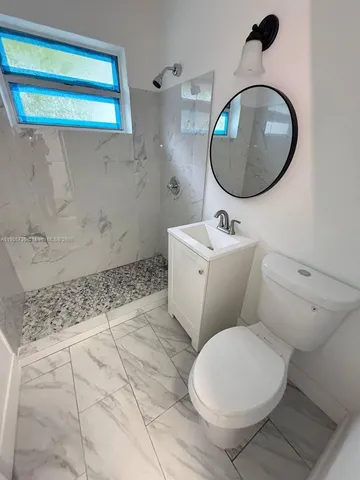 a bathroom with a sink mirror and toilet