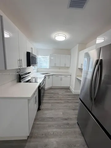 a kitchen with stainless steel appliances a refrigerator sink and a stove
