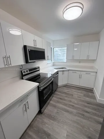 a kitchen with a stove microwave and sink