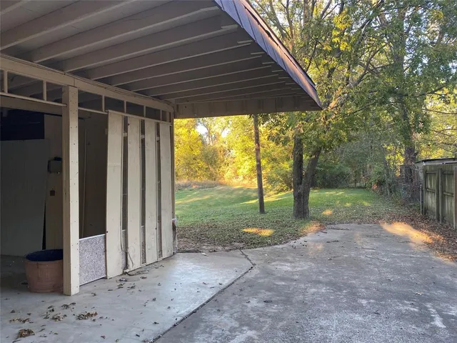 a view of a yard with wooden fence and a large tree