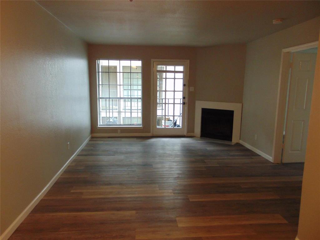 6108 Abrams Road, Unit 311 Dallas, TX 75231 - Photo 4 of 14 a view of an empty room with wooden floor and a window
