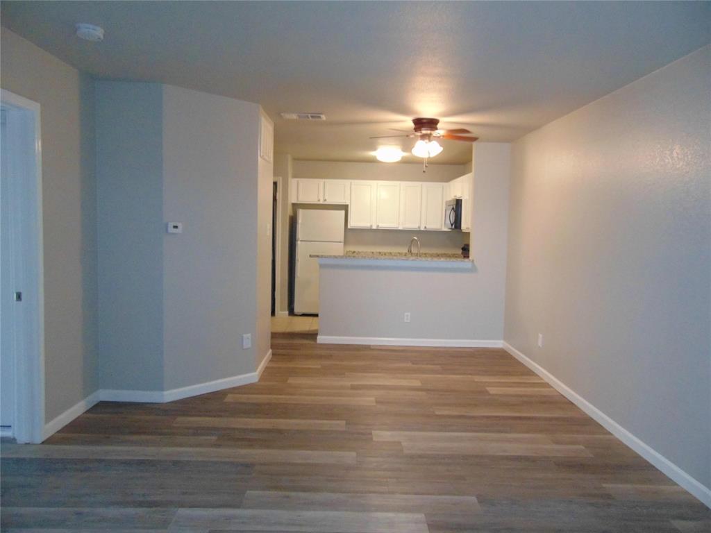 6108 Abrams Road, Unit 311 Dallas, TX 75231 - Photo 5 of 14 a view of a livingroom with wooden floor and a ceiling fan