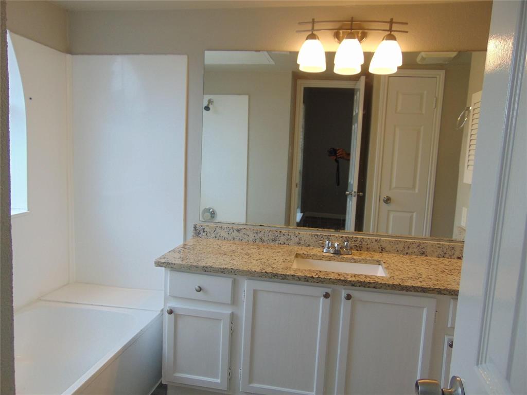 6108 Abrams Road, Unit 311 Dallas, TX 75231 - Photo 6 of 14 a bathroom with a granite countertop sink and a mirror