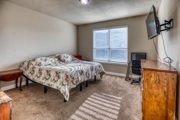 a bedroom with a bed lamp and a window