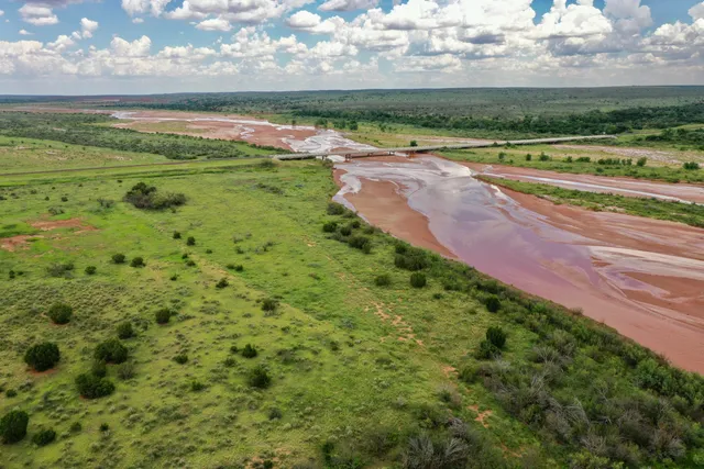 an aerial view of residential house with outdoor space and trees all around