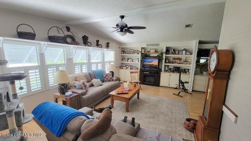 926 Yew Street Sebastian, FL 32976 - Photo 5 of 36 a living room with furniture gym equipment and a floor to ceiling window