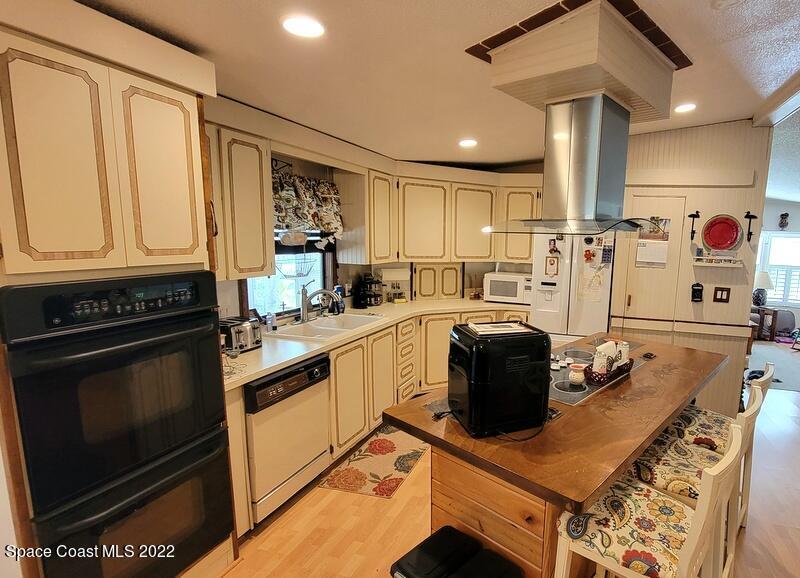 926 Yew Street Sebastian, FL 32976 - Photo 7 of 36 a kitchen with stainless steel appliances granite countertop a stove a sink and a microwave