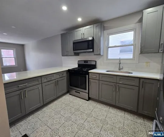 a kitchen with stainless steel appliances granite countertop a sink stove and microwave