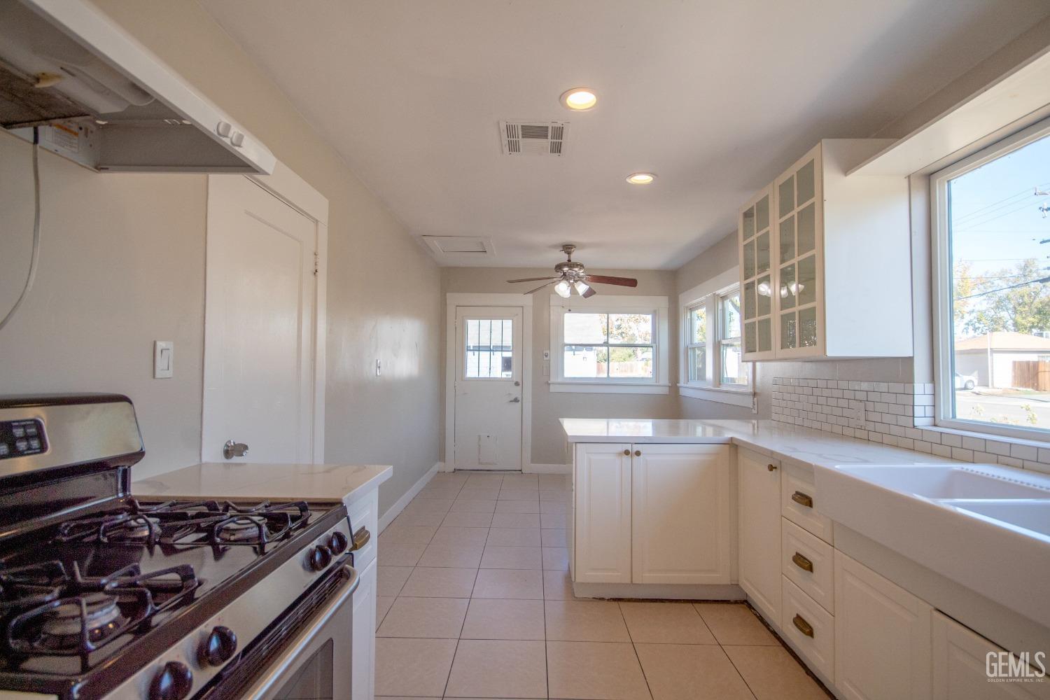 Undisclosed Address Bakersfield, CA 93305 - Photo 8 of 20 a kitchen with a stove and white cabinets