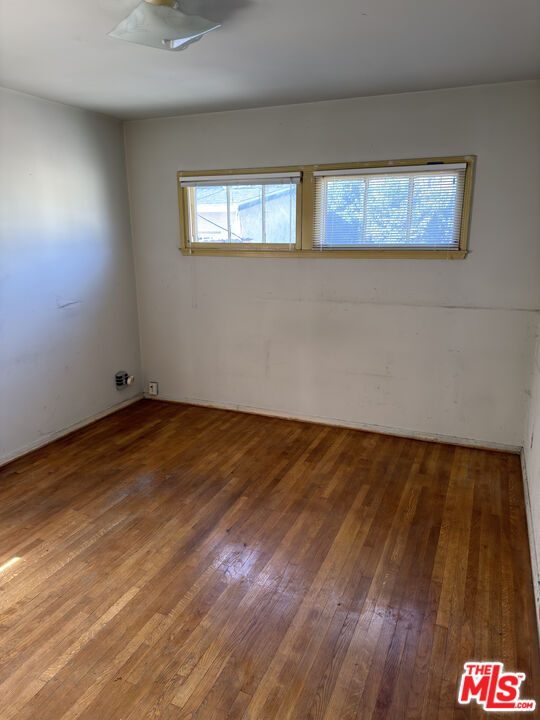 8230 Kyle Street Sunland, CA 91040 - Photo 11 of 13 a view of an empty room with wooden floor and a window