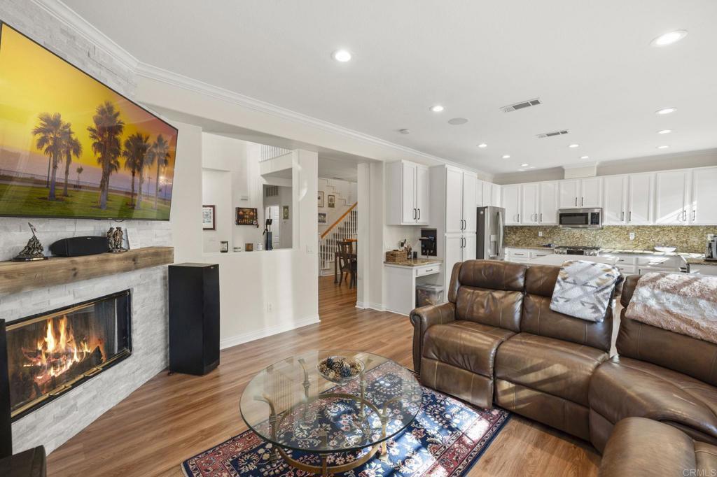 a living room with furniture and a fireplace with wooden floor