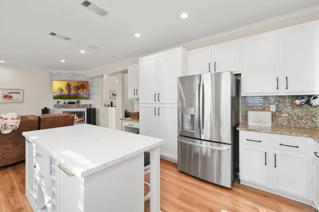 a kitchen with stainless steel appliances a refrigerator a stove a sink cabinets and wooden floor