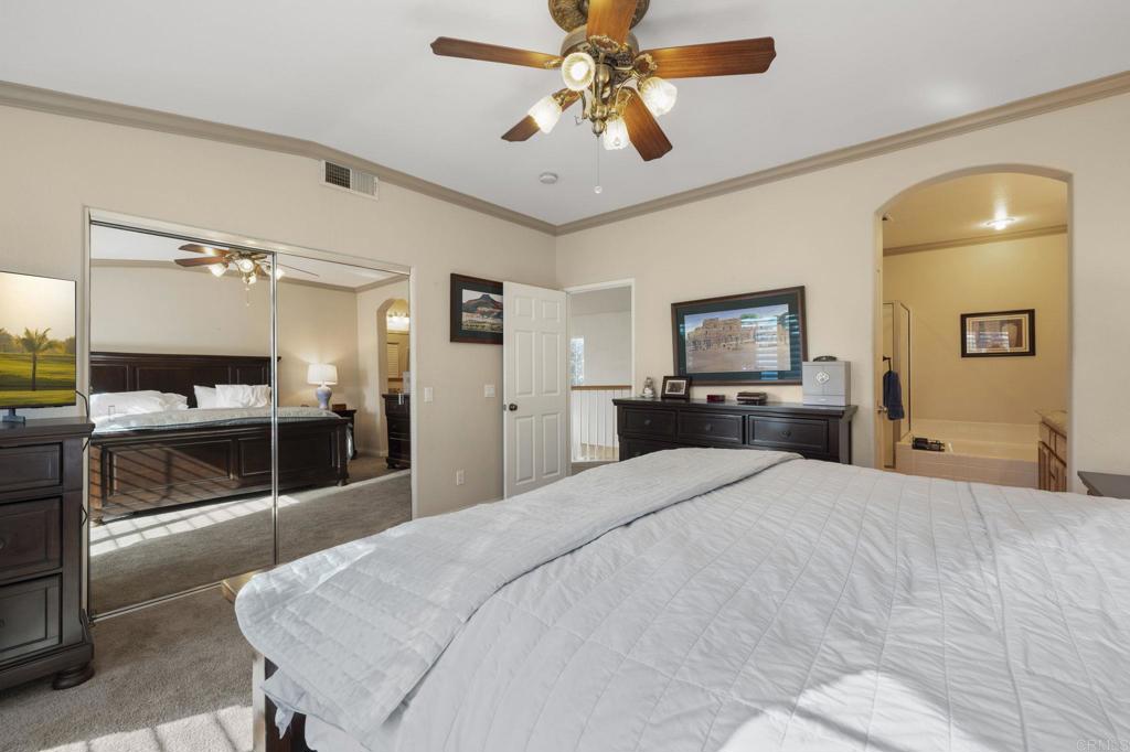 3033 Rancho La Presa Carlsbad, CA 92009 - Photo 17 of 46 a bedroom with a bed and a chandelier