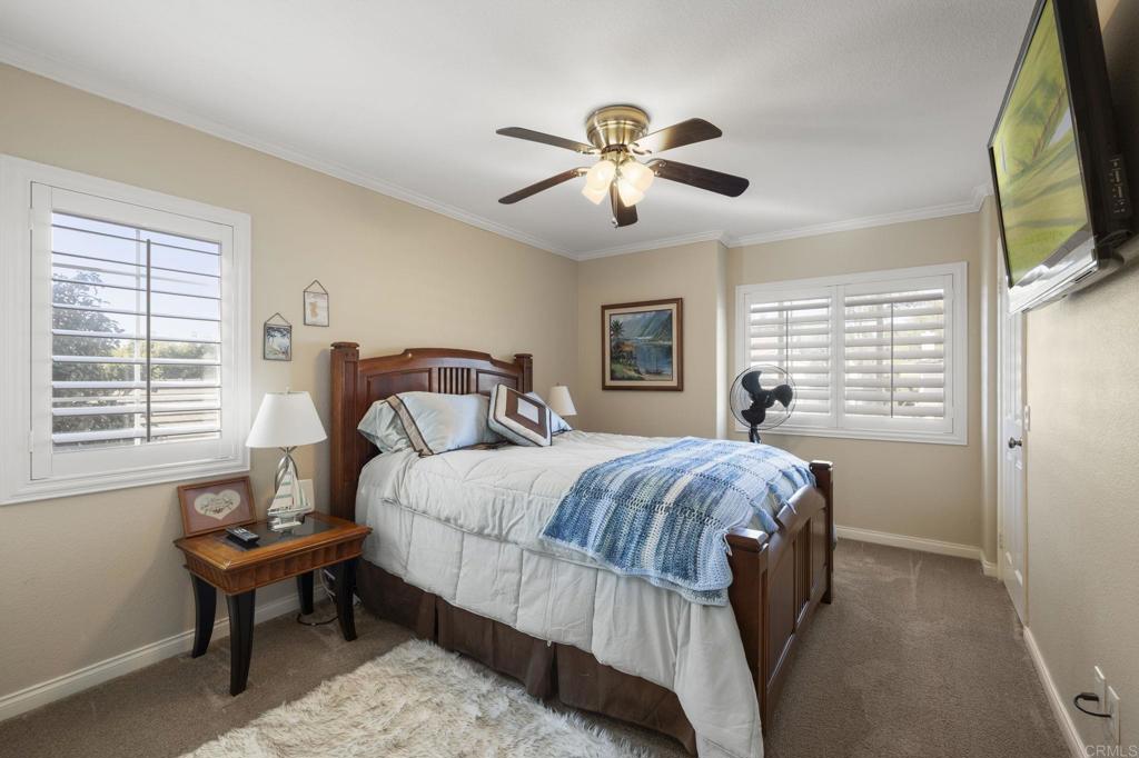 3033 Rancho La Presa Carlsbad, CA 92009 - Photo 20 of 46 a bedroom with a bed a window and a flat screen tv