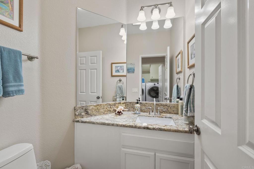 3033 Rancho La Presa Carlsbad, CA 92009 - Photo 21 of 46 a bathroom with a granite countertop sink a large mirror and vanity