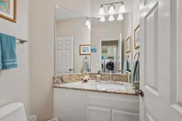 a bathroom with a granite countertop sink a large mirror and vanity