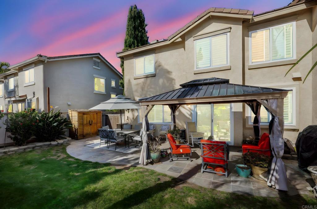 3033 Rancho La Presa Carlsbad, CA 92009 - Photo 25 of 46 a view of a patio with table and chairs under an umbrella