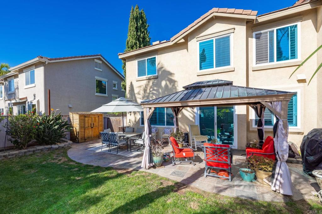 3033 Rancho La Presa Carlsbad, CA 92009 - Photo 30 of 46 a view of a patio with table and chairs under an umbrella