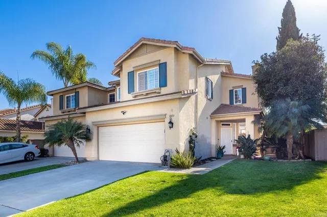 a front view of a house with a yard and garage
