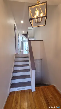 a view of entryway and hall with wooden floor