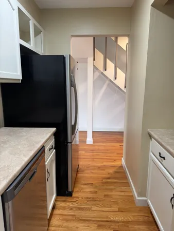 a walk in closet with wooden floor